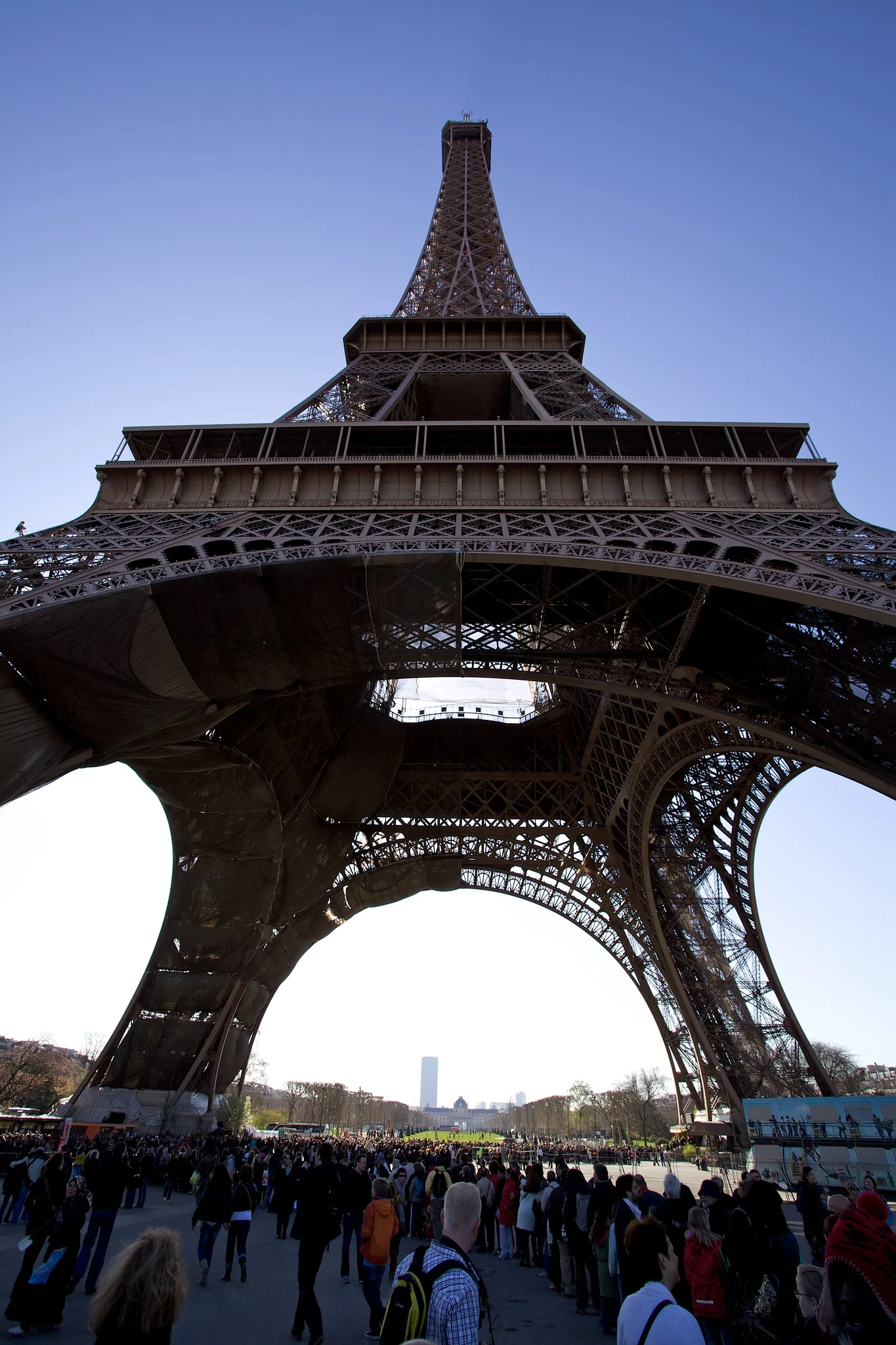 The Eiffel Tower photographed from directly underneath, looking up, exaggerating its height