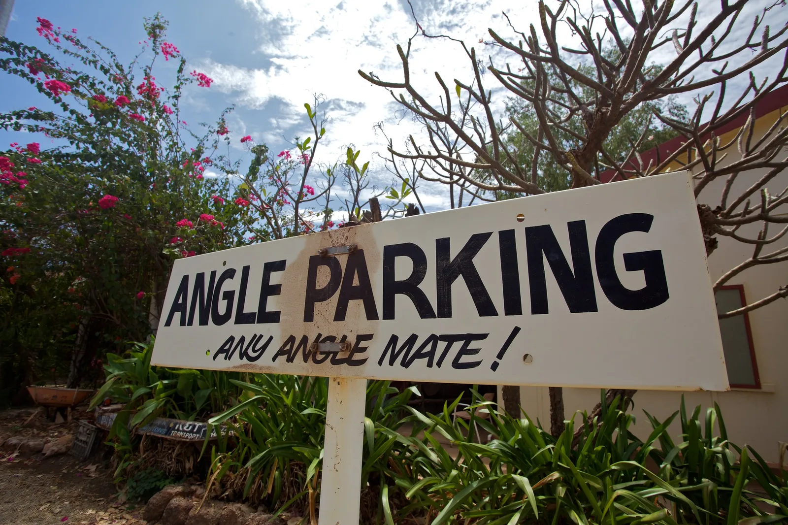 Hand painted Angle Parking sign among flowering bushes at an Australian outback pub