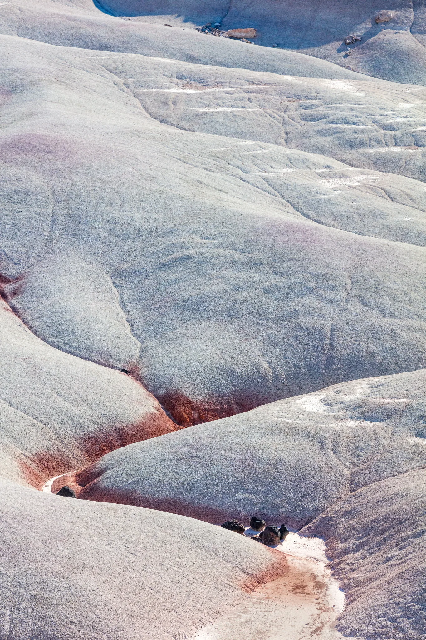 Abstract close view of pale bentonite clay hills with soft shadows carving out their rounded shapes