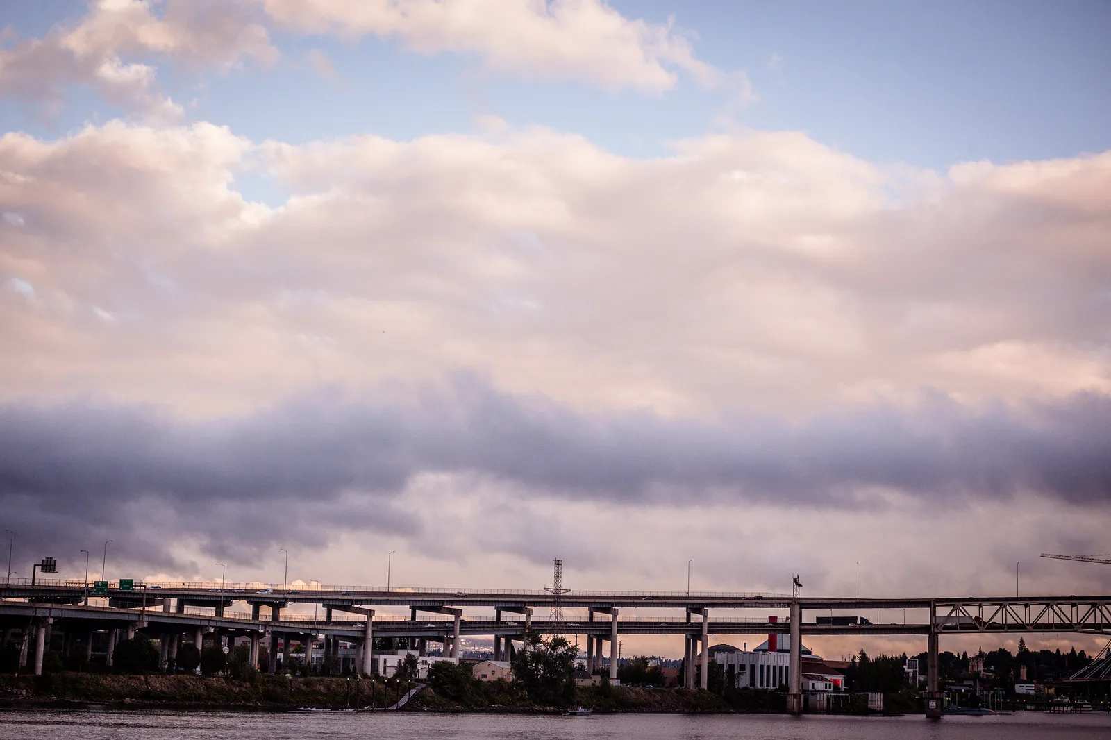 A curving elevated highway crossing a valley under a wide cloudy sky